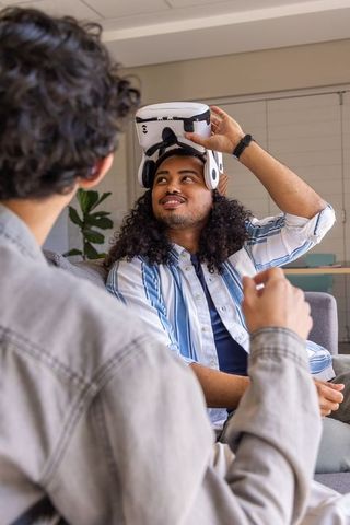 Diverse friends testing vr headset in modern lounge for tech collaboration and leisure