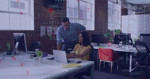 Man Leaning Reviewing Code with Woman at Laptop in Industrial Loft Office Coworking