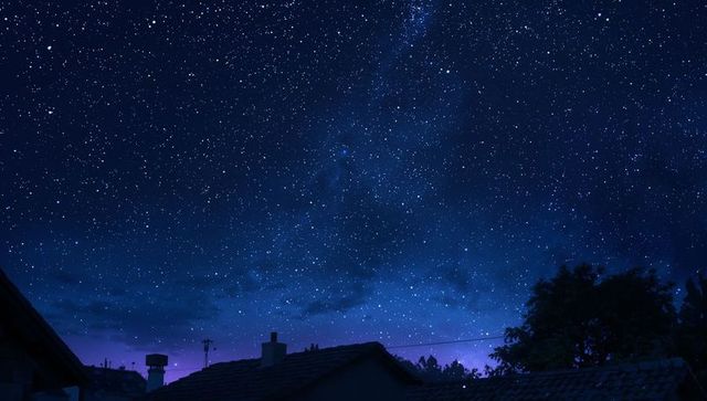 Star-Studded Night Sky with Silhouetted Rooftops and Milky Way