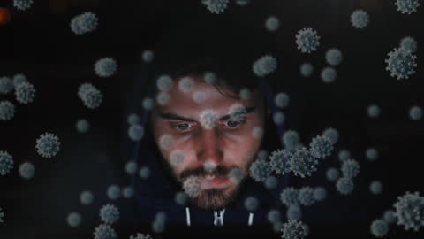 Man in Hoodie Viewing Viruses with Intense Focus