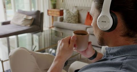 Man Relaxing with Coffee and Headphones in Modern Living Room