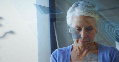 Senior Woman Using Tablet with Digital Interface Overlay