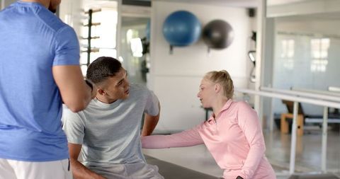 Rehabilitation Therapist Assisting Man with Back Pain in Clinic