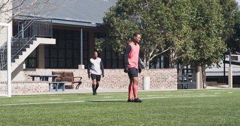 Soccer players preparing against urban backdrop, intense competitive spirit