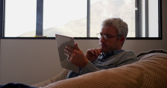 Pensive Man Using Tablet near Window at Home - Download Free Stock Images Pikwizard.com