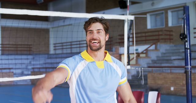 Caucasian man celebrates a victory on the volleyball court, with copy space. His energetic expression captures the excitement of sports in a school gym.