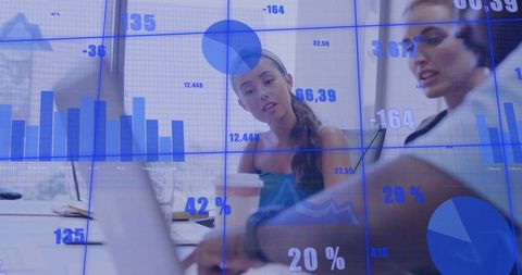 Collaborating over digital dashboards and analytics on laptop in modern office with skyline