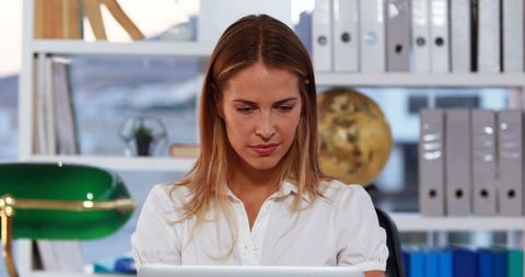 Focused Businesswoman Using Laptop in Creative Office Environment