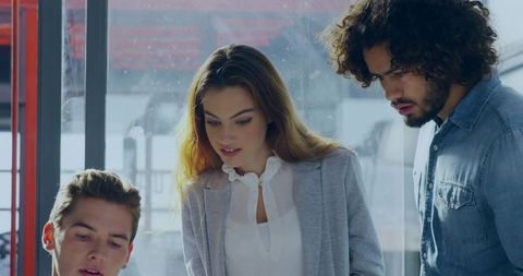 Focused Team Collaborating on Laptop in Modern Office Setting