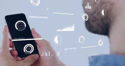 Holding smartphone with augmented reality analytics hud showing charts, graphs and gauges