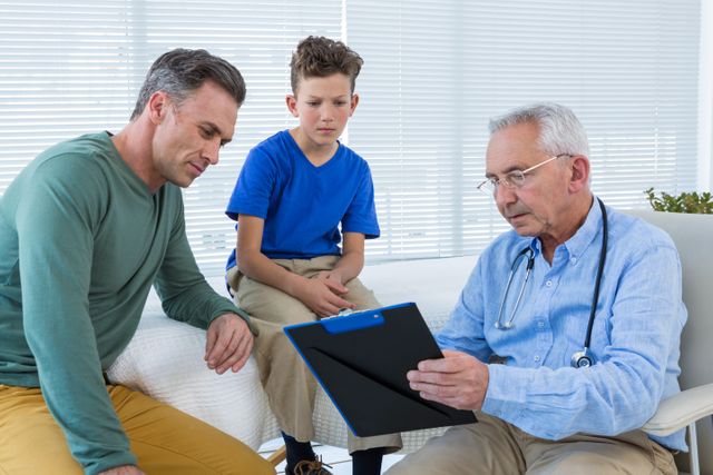 Doctor consulting with a young patient and his guardian in a clinical setting. The doctor is holding a clipboard and explaining medical reports. Useful for illustrating healthcare, medical consultations, family health, and doctor-patient interactions.