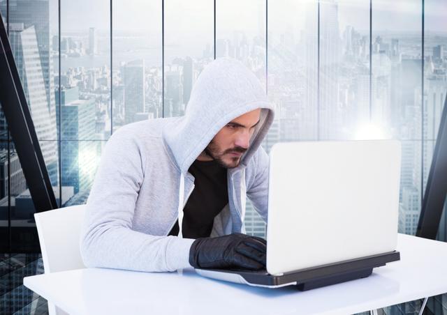 Digital composite of Criminal in hood with laptop in front of window