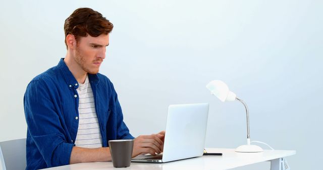 Focused Young Man Working on Laptop at Home Office Desk - Download Free Stock Images Pikwizard.com