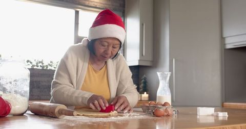 Senior woman baking holiday cookies in festive setting