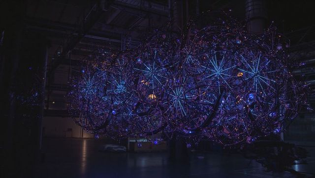 Futuristic luminous spherical art installation in industrial space