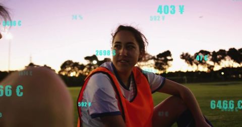 Young female soccer player resting at dusk with digital performance analytics overlay