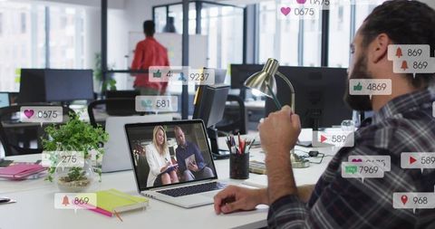 Man watching virtual presentation in open-plan office with social media overlays