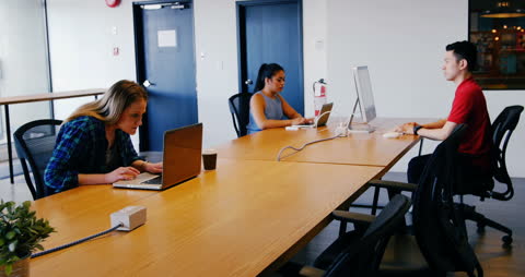 Focused Colleagues at Workspace Working on Laptops
