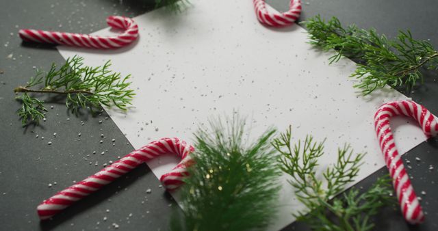 Image of christmas decorations with white card and copy space on black background. christmas, tradition and celebration concept.