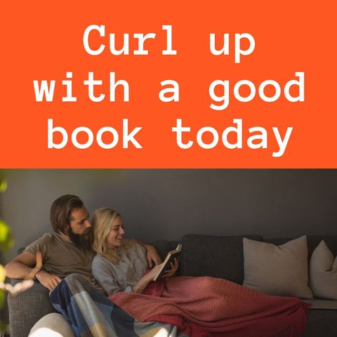 Couple relaxing on couch reading book together