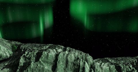 Aurora borealis shines over snowy winter mountains
