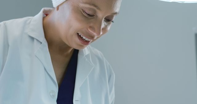 The female doctor, dressed in medical scrubs and a white coat, is smiling and seems engaged. This image can be used for healthcare-related promotional materials, advertisements for medical services, hospital websites, brochures, or articles focusing on healthcare and patient care.