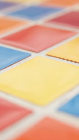 Vertical video shifting focus on colorful tile grid with red blue yellow geometric pattern