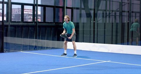 Man Practicing Padel Shots on Blue Indoor Court