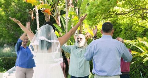 Celebratory wedding party with joyful diverse senior friends outdoors