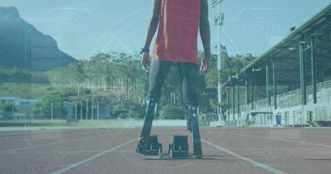 Determined Teenage Athlete Ready with Prosthetic Blades on Track at Stadium