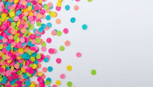 Neon paper confetti scattering from left with clean light gray space for text and design