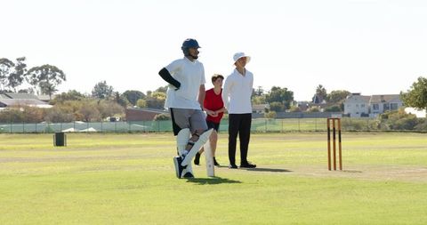 Youth cricket bowler overstepping crease with umpire signaling no-ball while batsman reacting