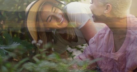 Laughing women sharing sunlit garden moment with coastal double exposure