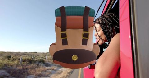 Leaning woman with braids sticking tongue out from pink car, coastal road trip travel