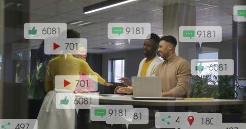 Diverse team collaborating at standing desk with laptop and social media engagement overlays