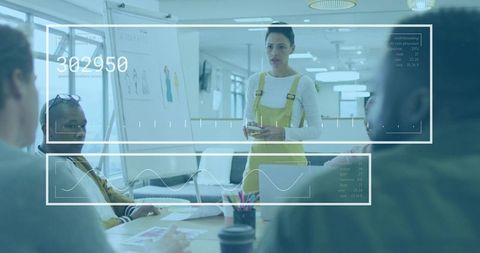 Woman presenting design mockups in modern office leading team collaboration with HUD analytics