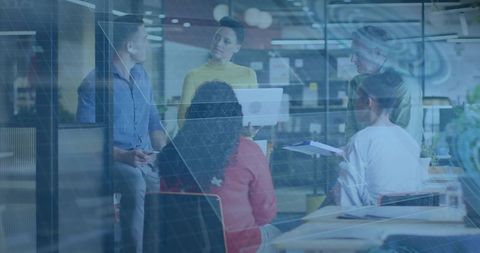 Leader presenting strategy on laptop while diverse team collaborating in modern open office