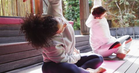 Couple Practicing Yoga Together on Wooden Deck Outdoor