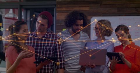 Team collaborating on digital network in modern office