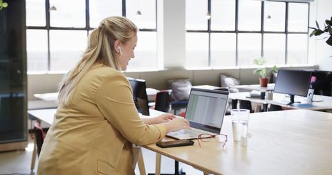 Happy Businesswoman Working with Laptop in Modern Office