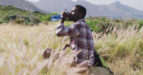 Man Resting on Hike In Scenic Mountain Field