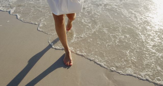 Close-Up of Barefoot Woman Walking on Beach Shore at Sunset - Download Free Stock Images Pikwizard.com