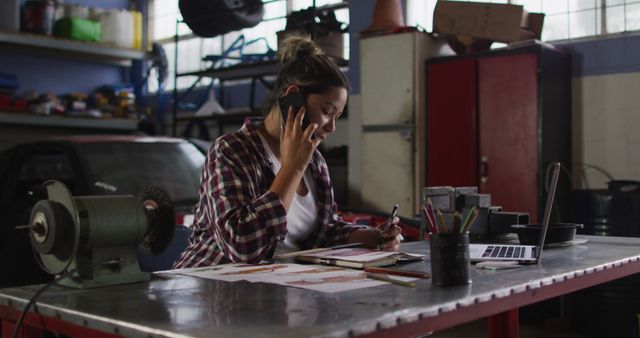 Female Mechanic Talking on Phone While Working in Auto Repair Shop - Download Free Stock Images Pikwizard.com