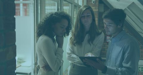 Diverse Team Collaborating on Tablet with Digital Overlay