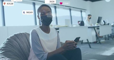 Businesswoman Wearing Mask and Holding Smartphone in Modern Office Space