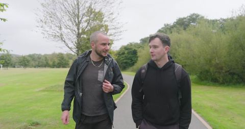 Two Friends Walking in Park Engaging in Relaxing Conversation - Download Free Stock Images Pikwizard.com