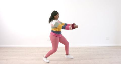 Woman practicing tai chi in colorful attire indoor serenity