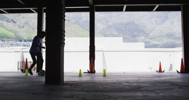 Silhouette of Boy Practicing Soccer Indoors Against Mountain Backdrop - Download Free Stock Images Pikwizard.com