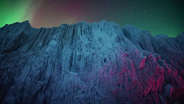 Aurora-lit glacial cliff with magenta highlights and starfield night sky for fantasy art