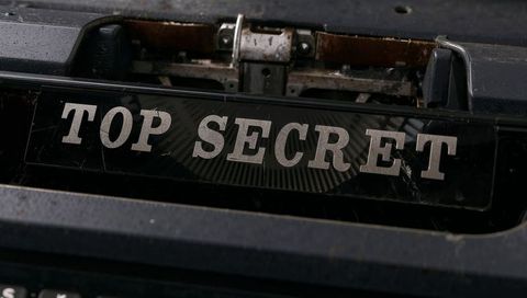 Vintage typewriter displaying top secret ribbon plate on worn platen with metal typebars